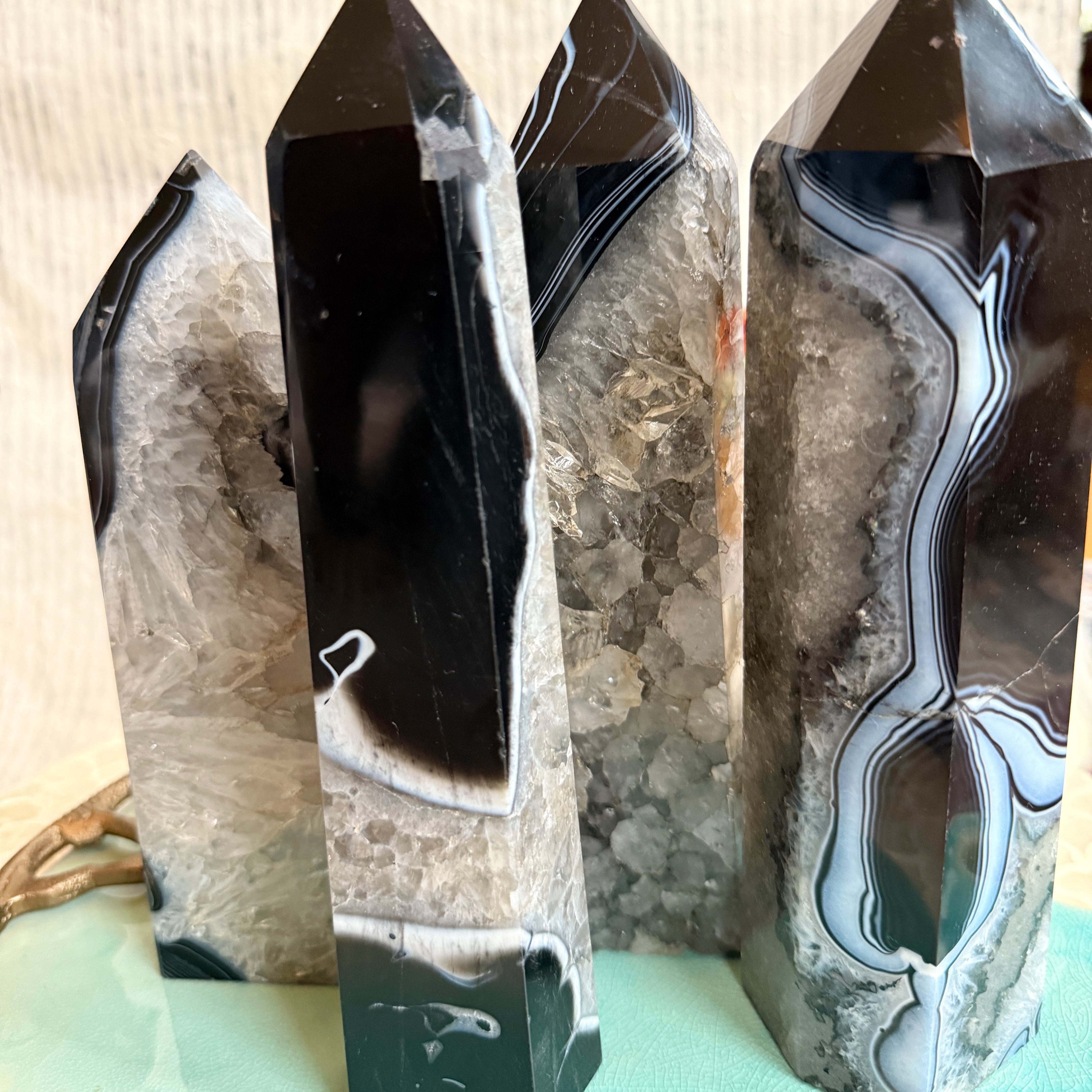 Banded Tuxedo Agate Tower crystal with black, white, and gray layers symbolizing balance, grounding, and strength — styled with autumn tones from Wild Alabaster’s Autumn Alchemy Collection.