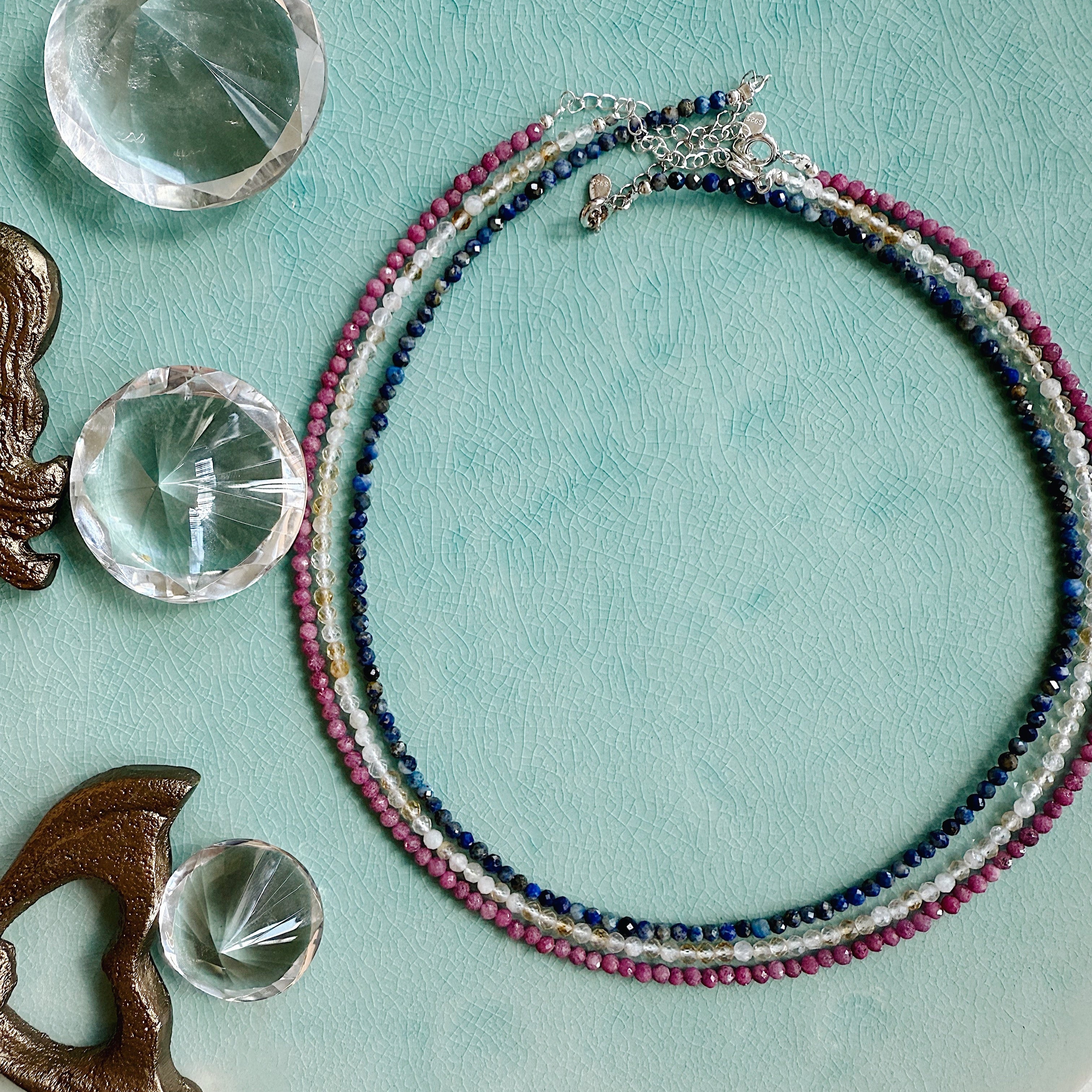 Handmade gemstone beaded necklace with faceted stones and gold hardware, styled for layering or worn alone.