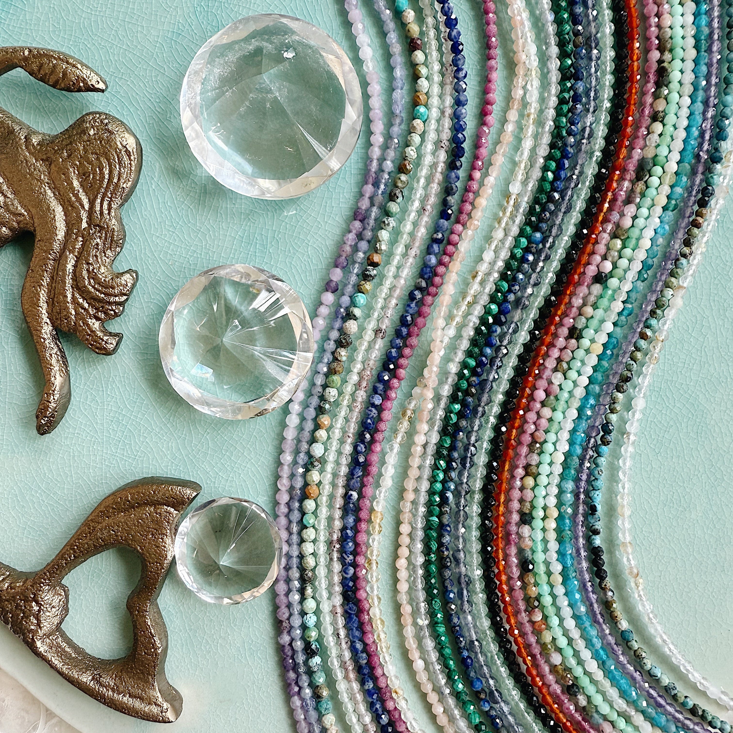 Handmade gemstone beaded necklace with faceted stones and gold hardware, styled for layering or worn alone.