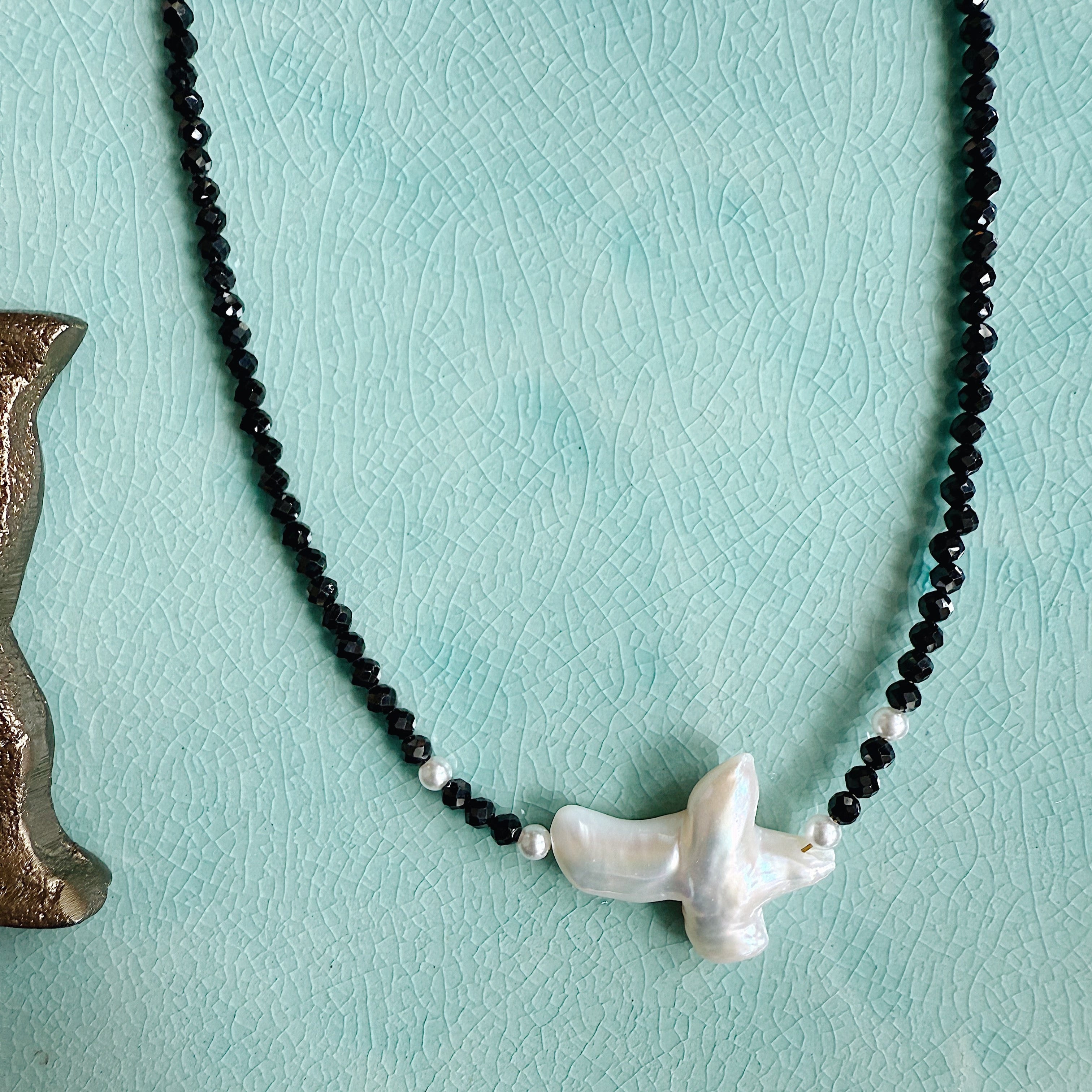The Eden Necklace with black tourmaline, freshwater pearl, and horizontal pearl cross