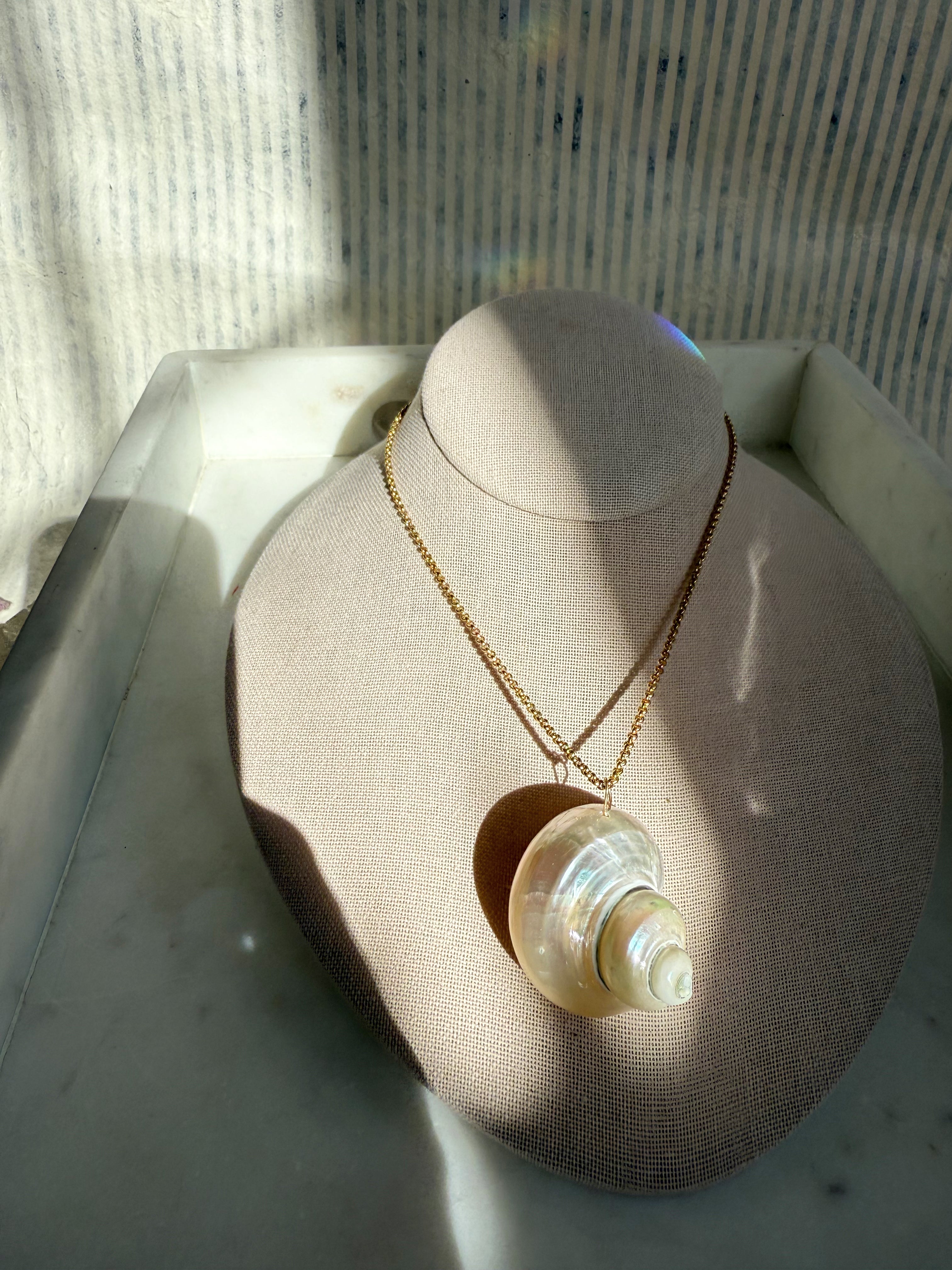 Amaris Collection by Wild Alabaster — handcrafted moon-inspired jewelry featuring shell pendants, gold collar, and pearl strands.