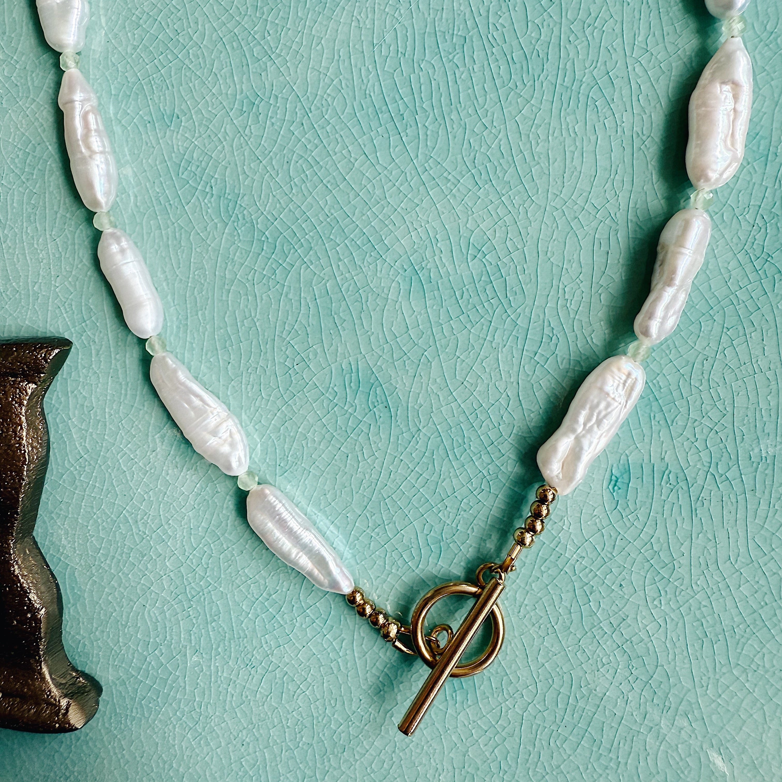 The Winnie Necklace with faceted peridot beads and a single freshwater pearl